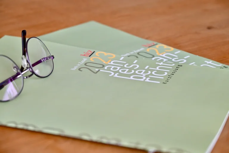 Grüne Jahresberichte liegen auf einem Holztisch