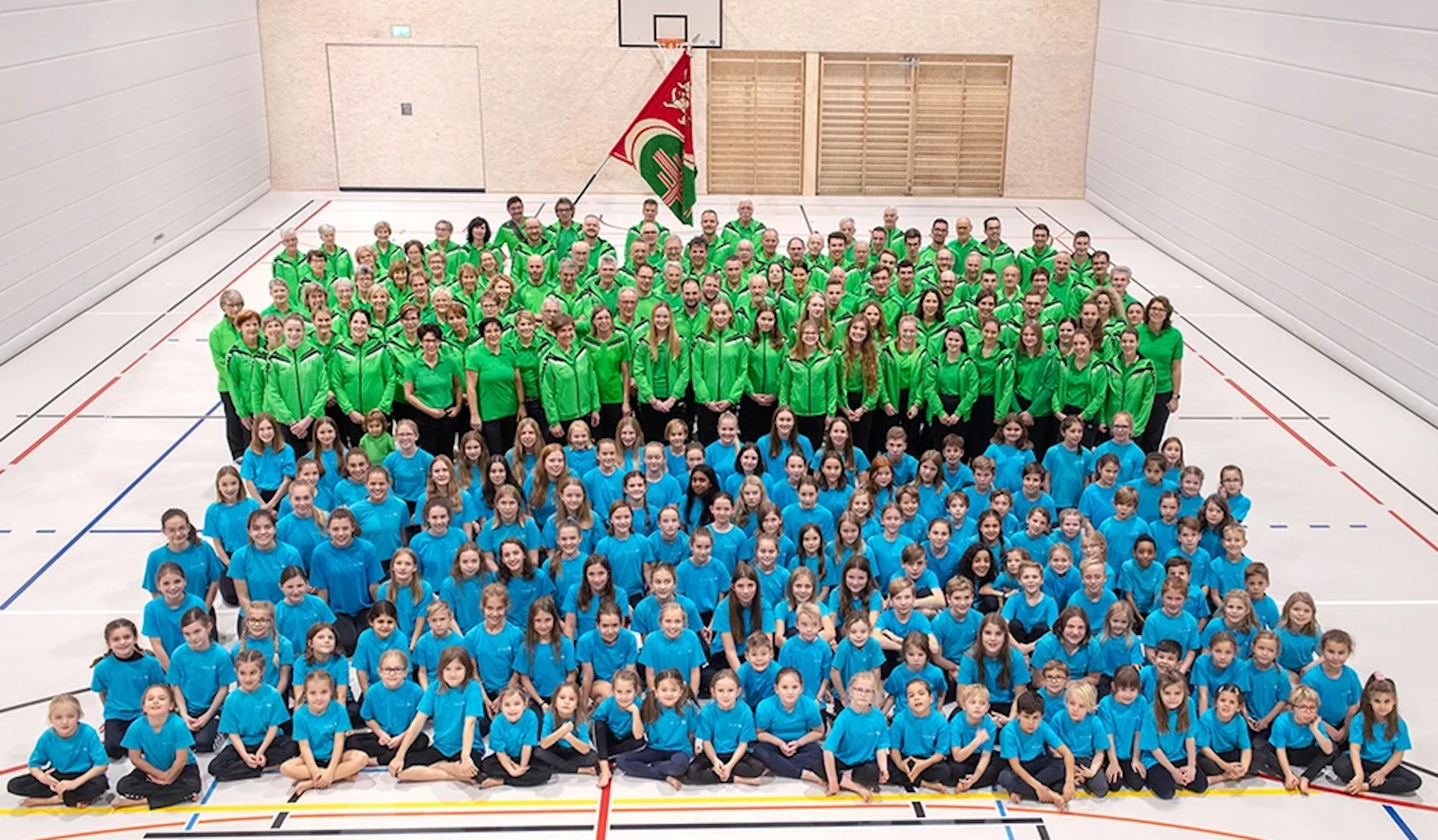 Gruppenfoto des TV Zuzwil mit grünen und blauen Vereinstenues